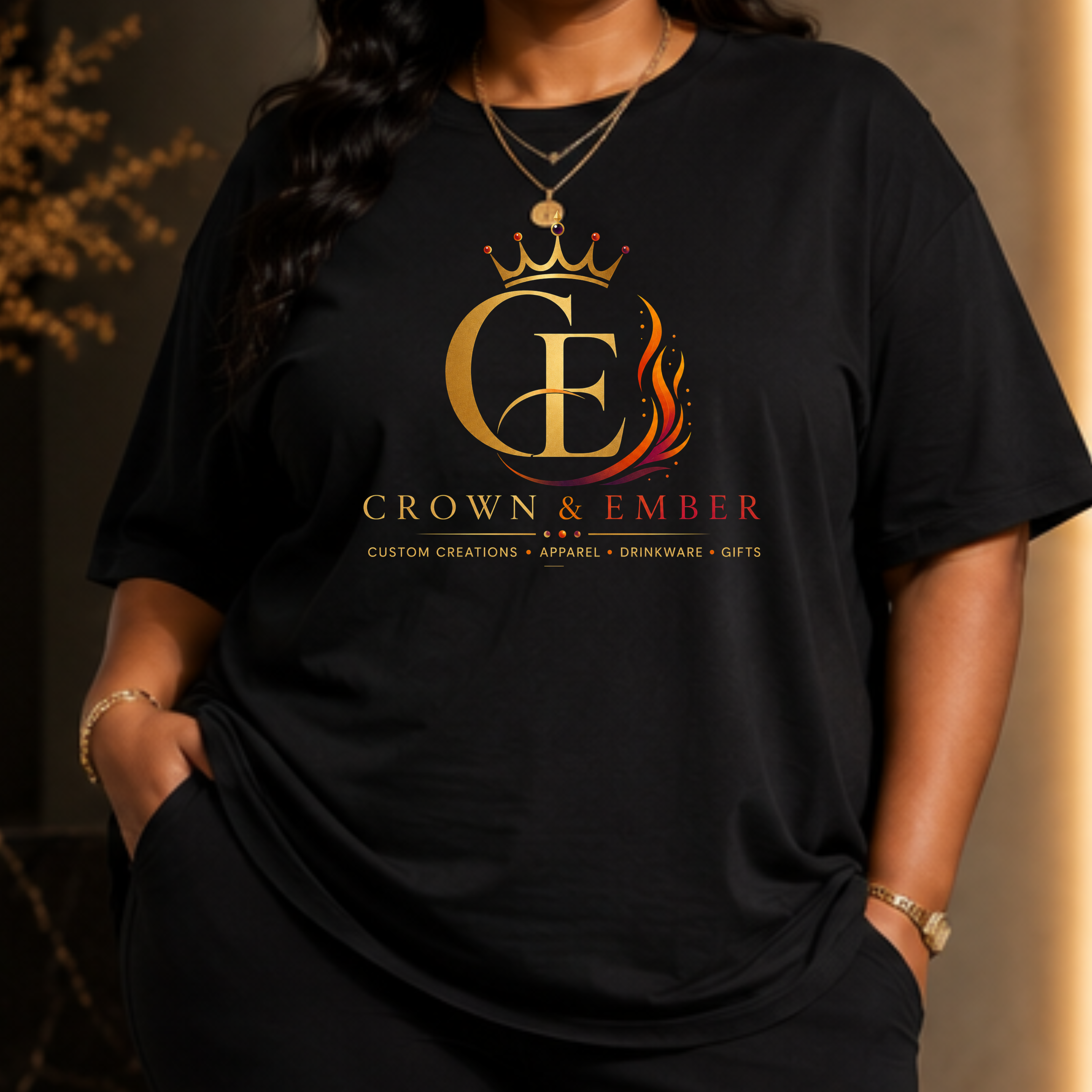 Woman wearing a black Crown and Ember t-shirt with a gold full chest logo and relaxed black lounge pants.